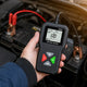 Car battery tester vs. multimeter: a BM550 battery tester clamped to a 12V car battery, showing 100% SOH and a Good result