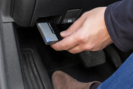 OBD2 code reader guide: plugging a Diagnostic Tool adapter into the OBD2 port under the dashboard