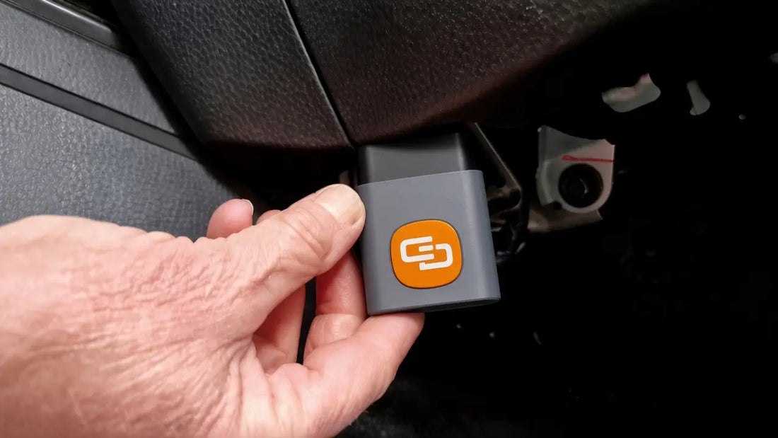 OBD2 scanner not connecting: hand plugging an OBD2 dongle into the vehicle port