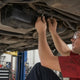 P0456 small EVAP leak checks: mechanic inspecting fuel tank hoses under a car on a lift